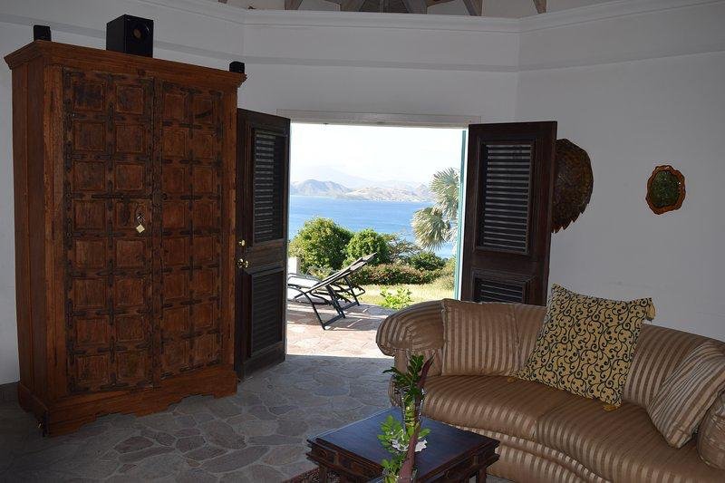 Luxury coastal home with stunning ocean views and outdoor balcony, perfect for relaxing and entertaining in Nevís. Spacious interior featuring elegant furniture and scenic landscape.