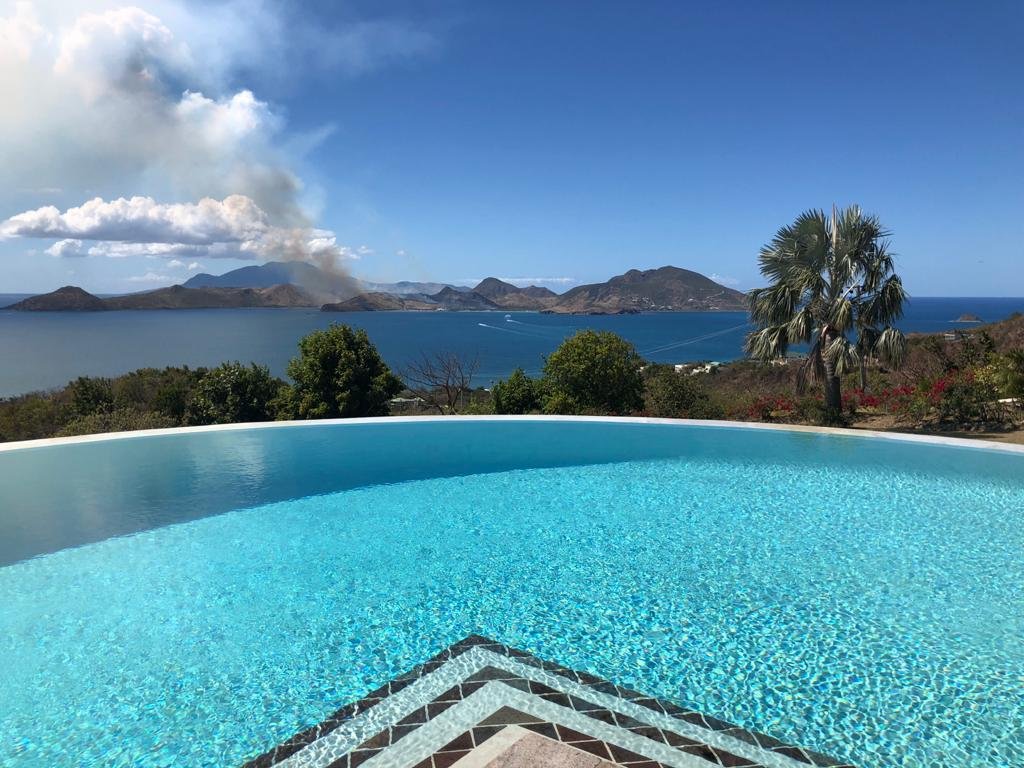 Stunning infinity pool overlooking the scenic ocean and volcanic islands near 17 Degrees North Realtors, perfect for luxury real estate in Nevis.