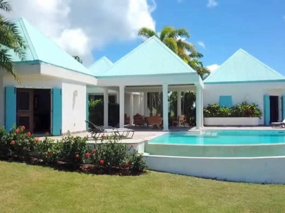 17 Degrees North Realtors luxury beachfront villa with pool and tropical garden in Evis, promoting exquisite coastal real estate.