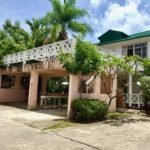 Spacious tropical home with balcony and lush greenery, located in Evis, perfect for real estate investment or vacation stays. Discover 17 Degrees North Realtors' property offerings.