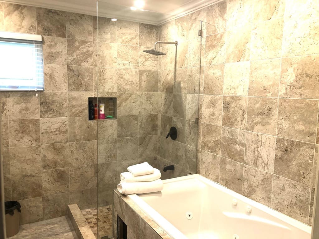 Luxurious bathroom with modern walk-in shower and soaking tub in a home listed by 17 Degrees North Realtors, highlights upscale real estate in Evans.