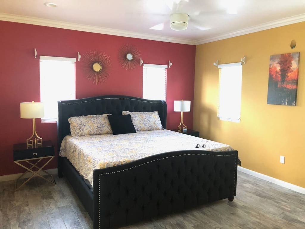 Cozy bedroom in a modern home listed by 17 Degrees North Realtors, featuring bold accent walls, stylish decor, and abundant natural light; perfect for buyers seeking comfortable living spaces.