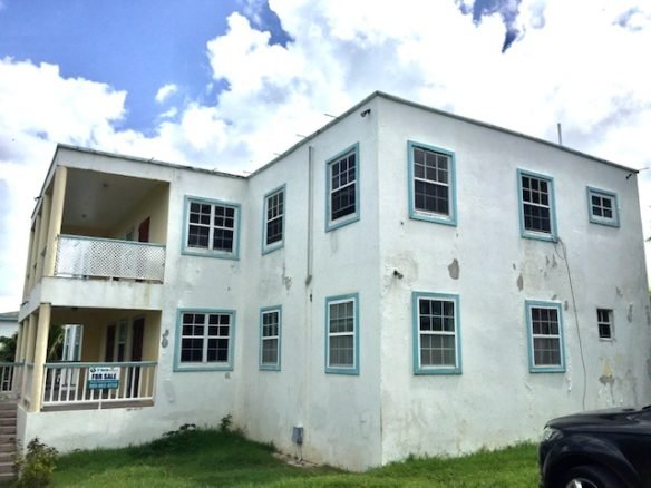 17 Degrees North Realtors property listing in Evis, showcasing a multi-family residential building with multiple windows and a balcony, ideal for investment or rental purposes.