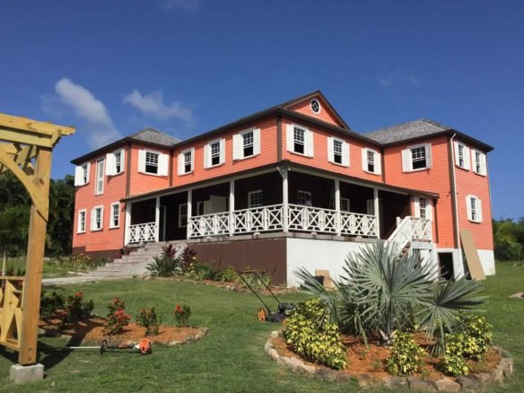 Luxurious coastal home with vibrant orange exterior, white accents, and spacious balconies, located in Evis. Perfect for real estate investment or seaside living by 17 Degrees North Realtors.