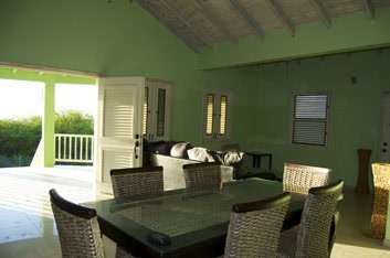 Modern living room with large windows, open access to balcony, and vibrant green walls, perfect for residential real estate in Nelsville.