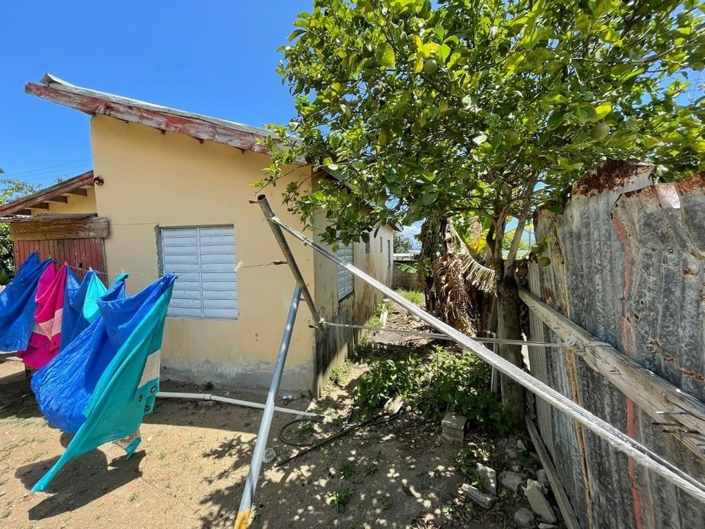 Colorful laundry hanging outside a small house in Evis, emphasizing affordable homes and local real estate options.