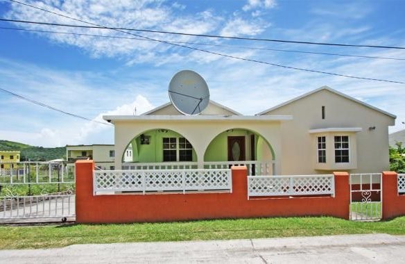 Modern single-family home with spacious front yard, satellite dish, and vibrant exterior paint, located in a scenic neighborhood ideal for real estate investment and family living.