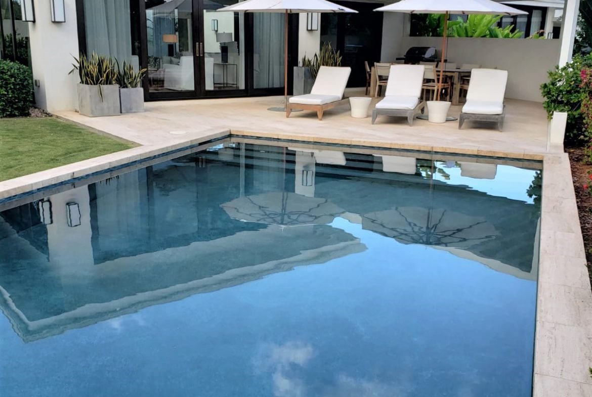 Luxurious modern home with private pool, outdoor lounge, and lush landscaping, ideal for relaxing and entertaining in paradise, showcasing premium real estate by 17 Degrees North Realtors.