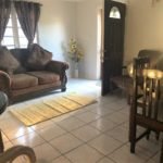 Cozy living room with sofa, dining area, and natural light in a home listed by 17 Degrees North Realtors. Ideal for those seeking comfortable and inviting residential spaces.