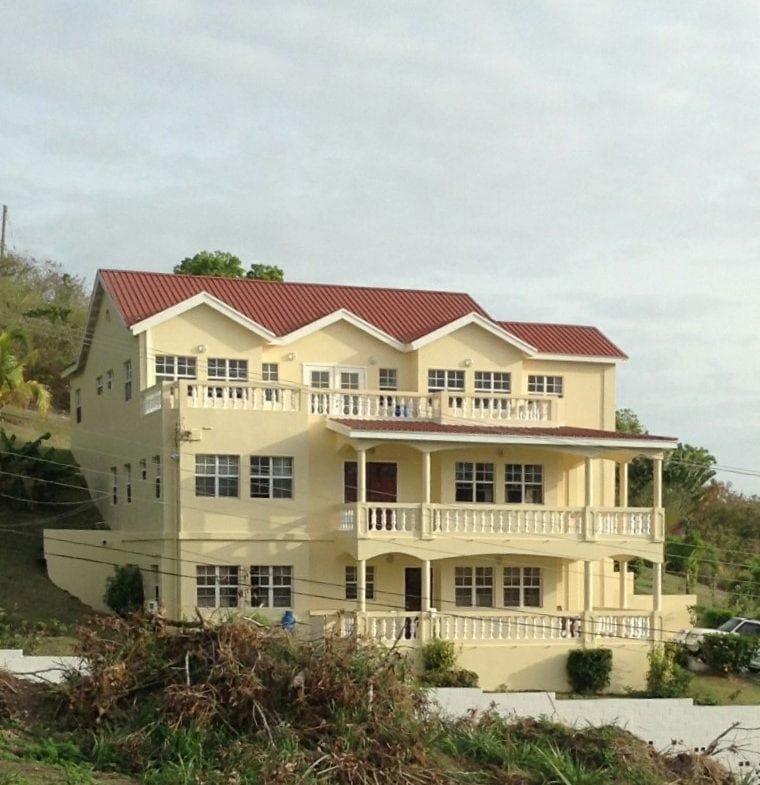 Luxury hillside home with multiple balconies and red-tiled roof in Evis, offering stunning views and modern amenities for real estate buyers.