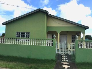 17 Degrees North Realtors property listing exterior shot of green house in Nevis, showcasing prime real estate opportunities.