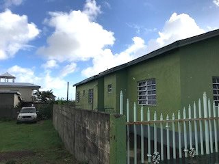 17 Degrees North Realtors property exterior in Evis, showcasing vibrant green houses and modern architecture.