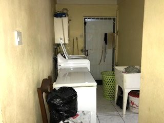 Laundry room with washer and dryer, laundry supplies, and cleaning tools in a small, functional space.