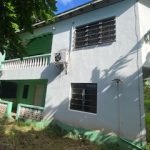 17 Degrees North Realtors property exterior in Nevis, featuring a charming two-story home with green accents, lush surroundings, and modern amenities.
