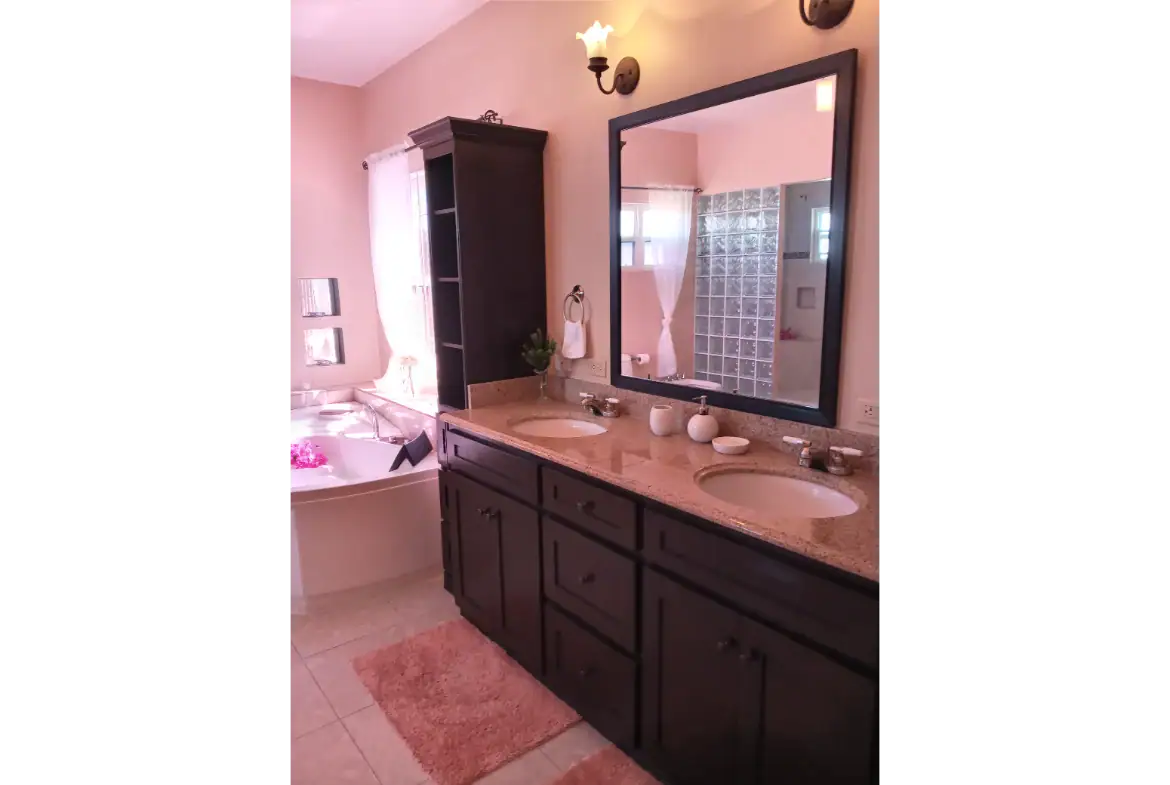 Luxurious bathroom with dual vanities, large mirror, and modern fixtures at 17 Degrees North Realtors. Elegant design, natural light, and stylish decor create a relaxing spa-like atmosphere.