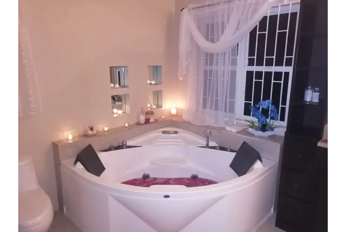 Elegant bathroom featuring a whirlpool tub with candles, soft lighting, and luxurious decor images from 17 Degrees North Realtors in Evis. Perfect for relaxing after a day of real estate viewing or home buying.