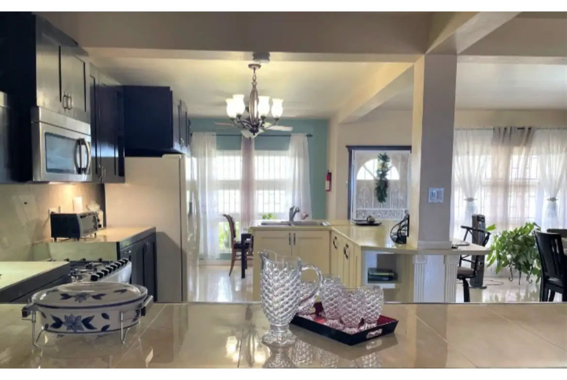 Bright kitchen with black and white cabinetry, stainless steel appliances, and elegant decor at 17 Degrees North Realtors in Evis. Spacious living area with natural light, perfect for family living and entertaining.