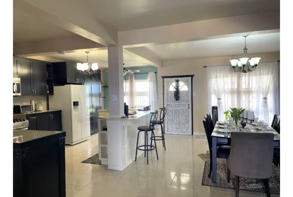 Spacious modern kitchen and dining area with sunlight, stylish decor, and elegant furnishings, perfect for a family home or entertaining guests in Evis neighborhood.