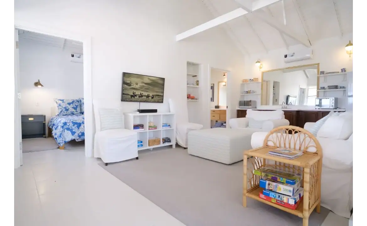 Bright and airy living room in a coastal-style home with white walls, comfortable seating, and modern décor, perfect for relaxing and entertaining in the 17 Degrees North Realtors property.