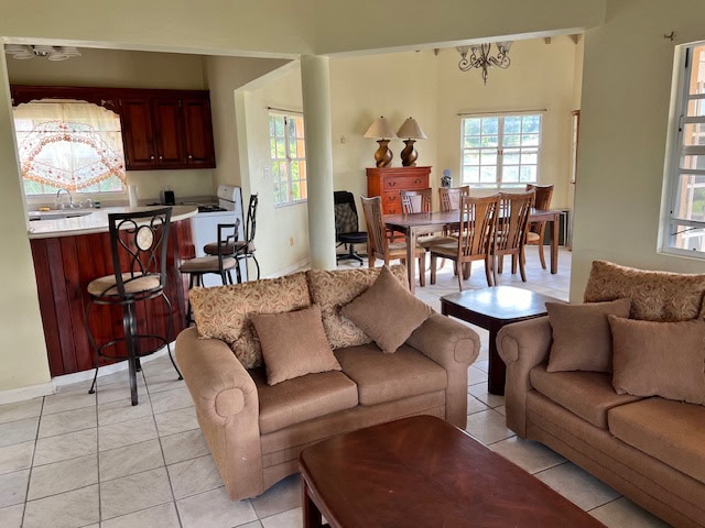 Spacious living room with comfortable sofas, open kitchen, and dining area in a family-friendly home near Evis. Perfect for relaxing and entertaining, featuring natural light and modern amenities.