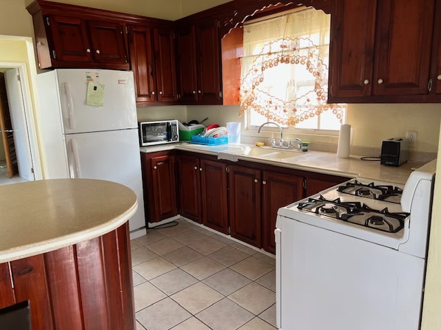 Refrigerator and kitchen appliances in a cozy, well-maintained kitchen with wooden cabinets and natural sunlight.