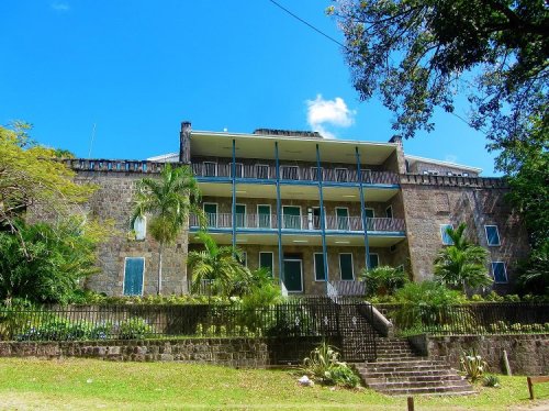 Stylish multi-level residential building with lush tropical landscaping, available for real estate investment with 17 Degrees North Realtors.